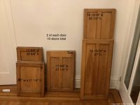 Photo showing all doors stacked against a wall with size labels on each distinct door. Notes indicate 2 of each door, 10 doors total.