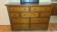 Front view of the nine drawer wooden dresser showing all drawer fronts and knobs.
