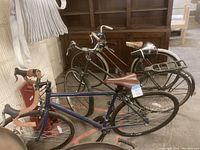 Three bicycles together showing blue, green, and maroon bikes with different styles and wear.