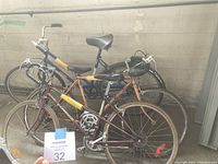 Three older style bicycles, purple Supercycle bike in front, orange bike in middle, blue and yellow bike in back.