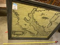 Framed vintage map with a cartographic design, featuring a region resembling Italy and surrounding areas, shown at an angle with visible frame detail.