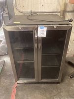 Front view of undercounter beverage cooler with dual glass doors and stainless steel handles