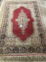 Top-down view of entire area rug showing the central red medallion and surrounding floral patterned border.