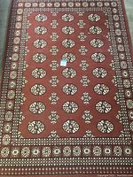 Full view of the rectangular red area rug displaying overall pattern and condition.