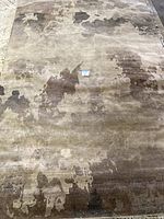 Full view of a rectangular rug with an abstract pattern in neutral browns and beige.