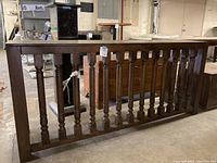 Side view showing the wooden spindles between horizontal supports at the table base.