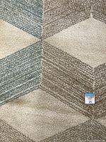 Close-up view of the zig zag lines in beige, brown, and blue colors on the rug.