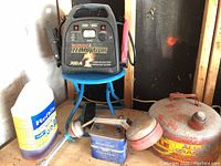 Full view of lot on blue stool showing Motomaster Eliminator 700A booster pack, Mallory Super Lantern Battery, vintage gas can, and ReFex container.