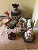 Photo showing German vase, Italian plant container, framed print, garden statue, fruit cluster decor and various pottery items.
