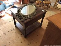 Decorative plastic framed oval wall mirror placed on wood table