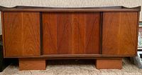 Full front view of closed credenza showing four sliding doors and walnut grain finish