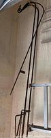 Three black metal shepherd hooks displayed leaning against a wall, showing curved hanging hooks at the top and long stakes at the bottom.