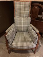 Front view of vintage wooden armchair with blue and white checkered cushions on seat, backrest, and armrests