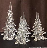 Group photo showing all four clear crystal art glass trees of varying sizes with faceted angular branch design and pointed tops.
