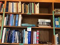 Shelf with assorted books including gardening, literature, and birdwatching titles