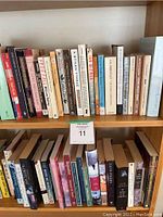 Close-up of upper shelf showing assorted books with colorful spines and various titles.