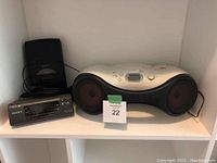 Sony CD-R/RW playback CD player, Sony dual alarm FM/AM clock radio, and Sony cassette recorder placed on a white shelf, showing overall condition and layout of items.