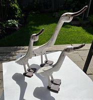 Set of three painted wood duck figurines displayed outdoors on white backdrop showing size difference and detailing.