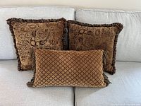 Set of 3 decorative cushions on light sofa showing front view and sizes