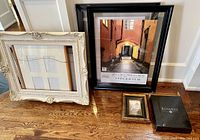 Nine various photo and art frames including two large black floating frames, assorted other frames with a variety of colors and sizes.