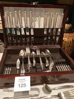 Wooden Pacific Silver Ltd chest open showing knives in slots, flatware in felt-lined bottom.