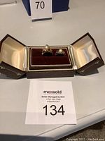 Two rings displayed in a hinged brown and cream jewelry box, top view