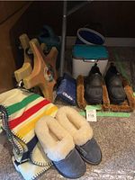 Several lot items displayed together: slippers, blanket, rollers, watering can, cooler, bag, cart handle visible