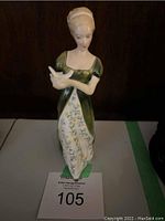 Frontal view of the Royal Doulton Veneta ceramic figurine of a woman holding a dove, showing detailed painting and floral pattern on dress.