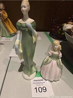 Front view of both ceramic figurines, Lorna and Penny, showing detailed colors and poses.