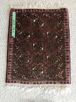 Photo of the small area rug laid flat showing front geometric and floral pattern with measuring tape on side