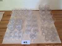 Group of clear crystal glassware and stemware pieces arranged on a flat surface, showing overall quantity and condition.