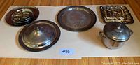 Full view of all serving ware items on white background showing the pot with lid and glass insert, platter with lid, serving trays and tiered food stands.