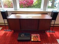 Front view of teak console with two speakers on stands, receiver and record in front