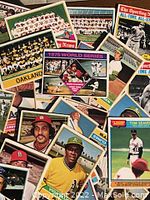 Close-up of baseball cards laid out showing player portraits and team photos from the 1970s.