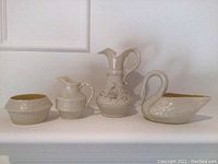 Overall view of three ceramic pieces including two pitchers and a swan-shaped dish