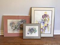 Three framed watercolor floral paintings arranged on floor, showing size differences and style.
