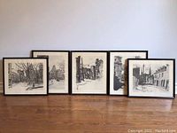 Five framed black and white street scene prints displayed on the floor showing overall lot contents.