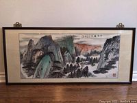 Full front view of framed Chinese landscape painting on floor against wall
