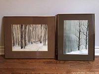 Two framed Pat Freeman winter landscape paintings side by side showing birch forests and snow.