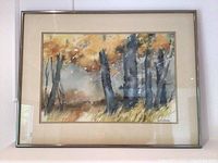 Frontal photo of the framed watercolor art showing autumn trees and the artist's signature in the lower right corner.