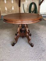 Full view of the round mahogany table, showing tabletop and carved pedestal base.