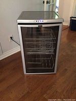 Full view of Kenmore wine cooler showing glass door, wire racks, and silver frame.
