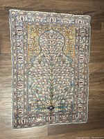 Full top view of the small Persian prayer rug laid flat on floor showing overall design and colors.
