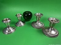 Four sterling silver candle sticks displayed with a green apple for size reference. Two smaller with smooth base, two larger with beaded detail.