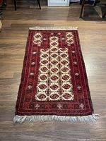 Full view of the rectangular hand knotted Persian rug laid flat, showing the entire length with fringed edges and geometric pattern.