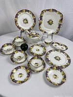 Full assortment of tea set pieces arranged on white background