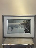 Full view of framed print against wall on small table