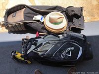 overview of travel bag, straw hats and Callaway stand bag