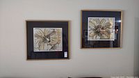 Pair of two framed floral art prints signed by N. S. Locum, hung on wall, showing frames, mats, and print details.