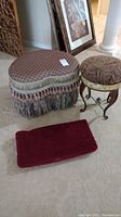 Overall view of two footstools and small rectangular rug placed on carpeted floor.